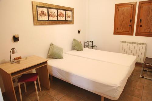 Habitación pequeña con cama y escritorio. en Apartamento Sarzaleta, en Galdeano