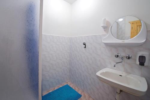 ein Bad mit einem Waschbecken und einem Spiegel in der Unterkunft Ubytování LENKA in Bělá pod Pradědem