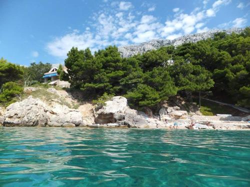 a group of people in the water near an island at Apartments Juric in Mimice