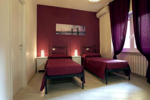 Appartamenti Romatour في روما: غرفة نوم بسريرين وجدران ارجوانية
