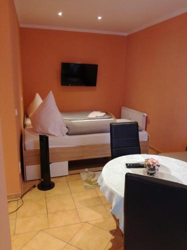 a bedroom with a bed with a tv on the wall at Pension Schloßwache-Zerbst in Zerbst