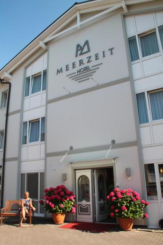 a woman sitting in front of a merriott hotel at Hotel Meerzeit Binz in Binz