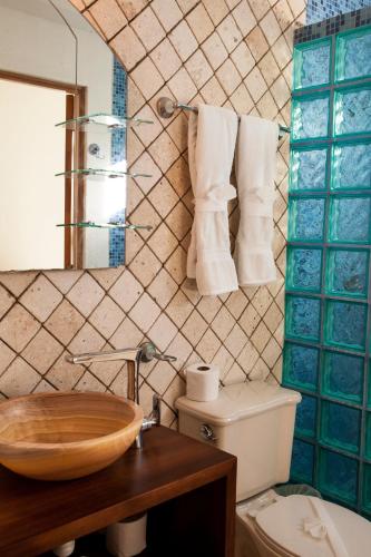 a bathroom with a toilet and a sink and a mirror at Las Olas Condominium #207 in Playa del Carmen