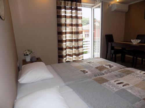 a bedroom with a bed and a window with a table at Apartman Bogić in Golubac