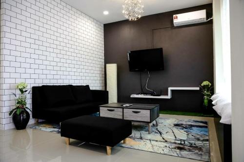 un soggiorno con divano e TV di Sibu Swanhouse No.3 a Sibu