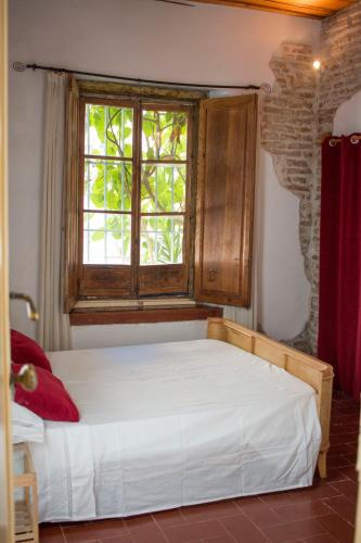 a bed in a room with a window at Casa histórica Gines in Ginés