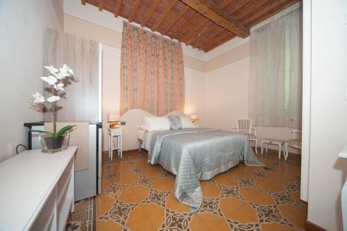 1 dormitorio con 1 cama, mesa y sillas en Lucca Relais, en Lucca