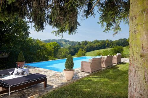 a pool with chaise lounge chairs and a table and a pool at Karavla Private Villa in Šentilj