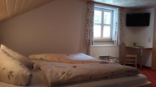 a bedroom with two beds and a window at Pension Backstuba in Partenen