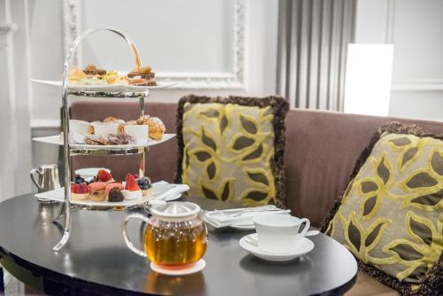 a table with a tray of pastries and tea at The Pierre, A Taj Hotel, New York in New York