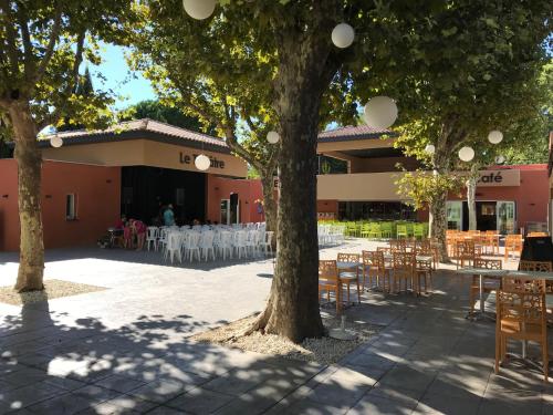 een binnenplaats met tafels en stoelen voor een gebouw bij L'Hôtel du Méditerranée in Argelès-sur-Mer