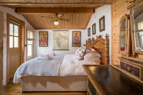a bedroom with a large bed in a room with wooden walls at Tolcarne Beach Colonial Restaurant and Rooms in Newquay