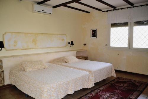 una camera da letto con due letti e due finestre di Casa del artista ad Arona