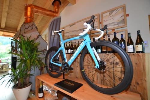 a blue bike parked on a table with wine bottles at Dolomiti Lodge Alverà in Cortina dʼAmpezzo