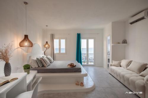 a white room with a bed and a couch at Manios Suites in Agia Anna Naxos