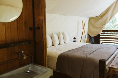 a bedroom with a bed with a tub in it at Under Canvas Mount Rushmore in Keystone
