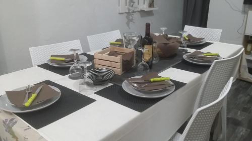 a white table with plates and utensils on it at Casa Del CicloTurista in Santadi