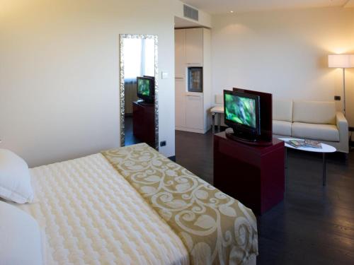a hotel room with a bed and a television at Grand Hotel Mattei in Ravenna
