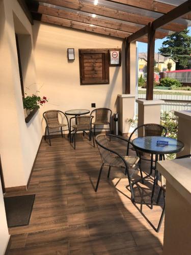 a patio with tables and chairs on a building at Kristály apartmanok in Kisvárda