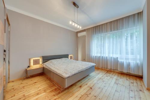a bedroom with a bed and a large window at Central Apartment in Sofia
