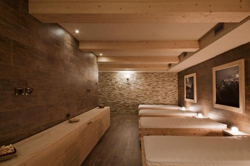 a row of beds in a room with a brick wall at La Torretta in Passo del Tonale