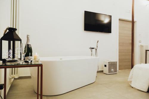 a white bath tub in a room with a table at Diomede Rooms - Manfredi Homes&Villas in Manfredonia