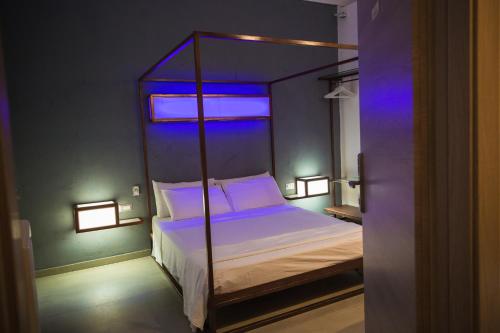 a bedroom with a canopy bed with blue lighting at Diomede Rooms - Manfredi Homes&Villas in Manfredonia