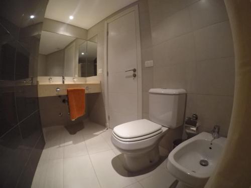 a bathroom with a white toilet and a sink at Wind Tower in Punta del Este