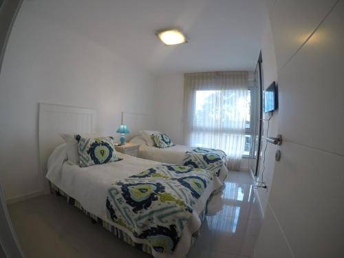 a bedroom with two beds and a window at Wind Tower in Punta del Este
