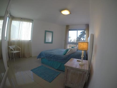 a bedroom with a bed and a table with a lamp at Wind Tower in Punta del Este
