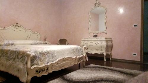 a bedroom with a white bed and a mirror at Villa Berra - Via Postale 63/A in Berra