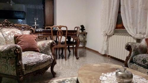a living room with a table and chairs at Villa Berra - Via Postale 63/A in Berra