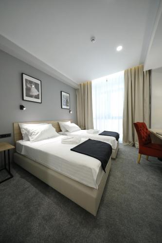 a large bedroom with two beds and a chair at Teatro Verdi Boutique Hotel in Zadar