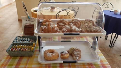 two trays of donuts and pastries on a table at Mariposa B&B in San Vito lo Capo