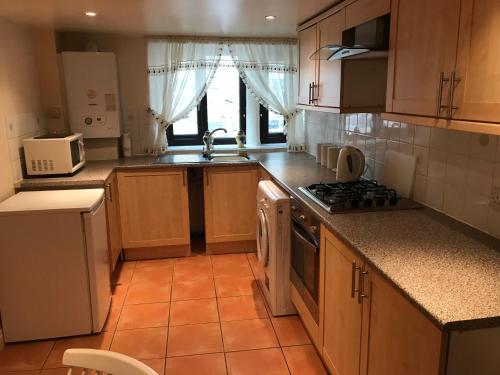 a kitchen with a sink and a stove top oven at The Cottage, cosy 2 bedroom pet friendly perfect for contractors free secure parking,CCTV in Leeds