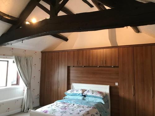 a bedroom with wooden walls and a bed with blue pillows at The Cottage, cosy 2 bedroom pet friendly perfect for contractors free secure parking,CCTV in Leeds