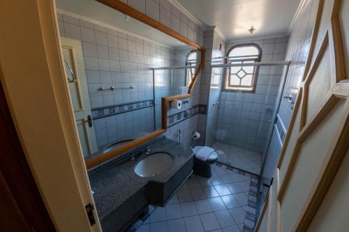 a bathroom with a sink and a toilet at Via Genova Parque Hotel in Serafina Corêa