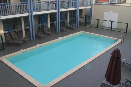 une grande piscine au sommet d'un immeuble dans l'établissement Les Balcons de L'Ocean, à Biscarrosse