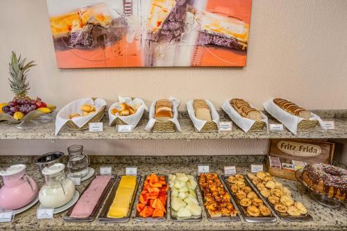 a buffet with different types of bread and pastries at Hotel Express Canoas in Canoas