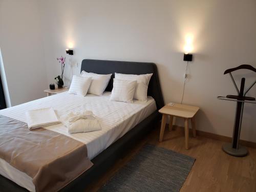 um quarto com uma cama grande com lençóis brancos e almofadas em Urban Nest Apartment em Bucareste