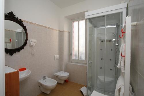 a bathroom with a shower and a toilet and a sink at Hotel Roma in Scanno
