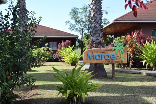 a sign for a mote entrance in front of a house at Marae - Cabañas Premium in Hanga Roa