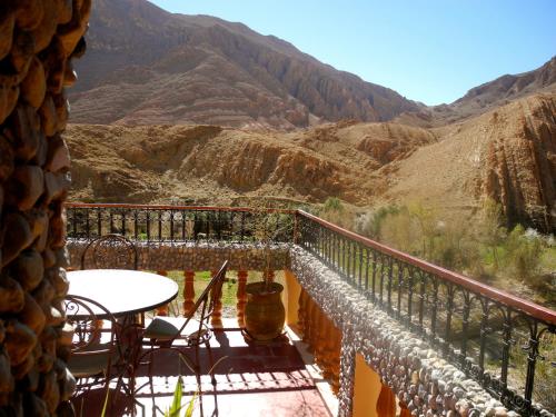 a balcony with a table and a view of a canyon at Maison d'Hôte Valentine in Tinerhir
