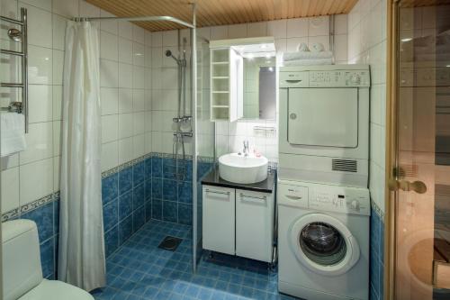 uma casa de banho com uma máquina de lavar roupa e um lavatório em Luxury City Center Apartments em Helsinque