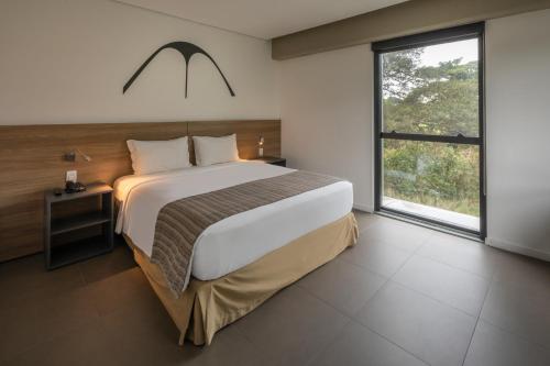 a bedroom with a large bed and a large window at Linx Galeão in Rio de Janeiro