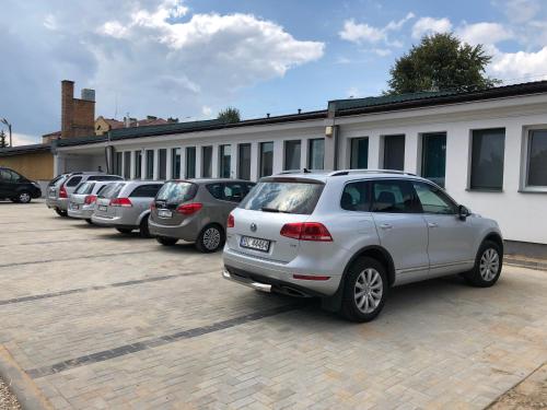 een rij auto's geparkeerd op een parkeerplaats bij M&A GUEST ROOMS in Łomża