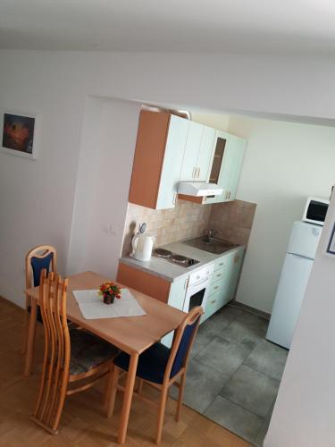 une petite cuisine avec une table en bois, une table et des chaises dans l'établissement Victoria Apartment, à Ljubljana
