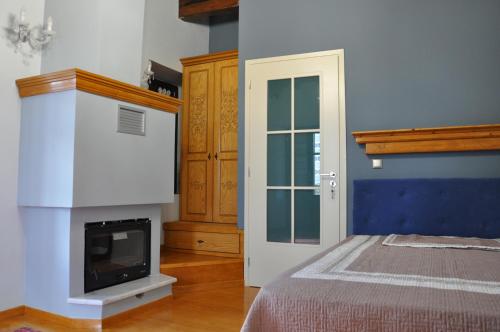 a bedroom with a bed with a fireplace and a tv at Apostolia's Small House Bed and view in Anavrití