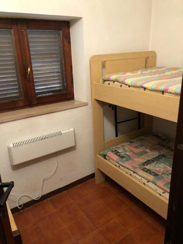 a room with two bunk beds and a window at Via Osvaldo Moretti(complessoShalimar) in Ovindoli
