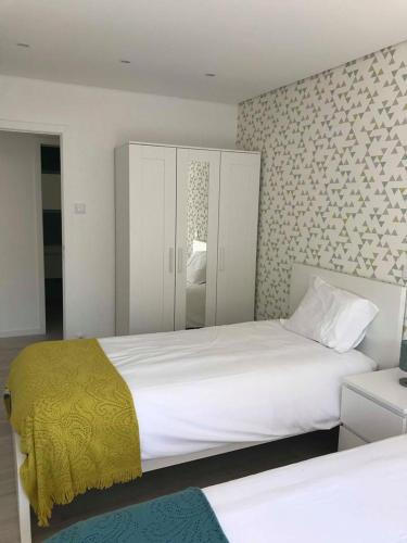 a bedroom with two beds and a yellow blanket at Calua apartment in Povoa de Varzim in Póvoa de Varzim